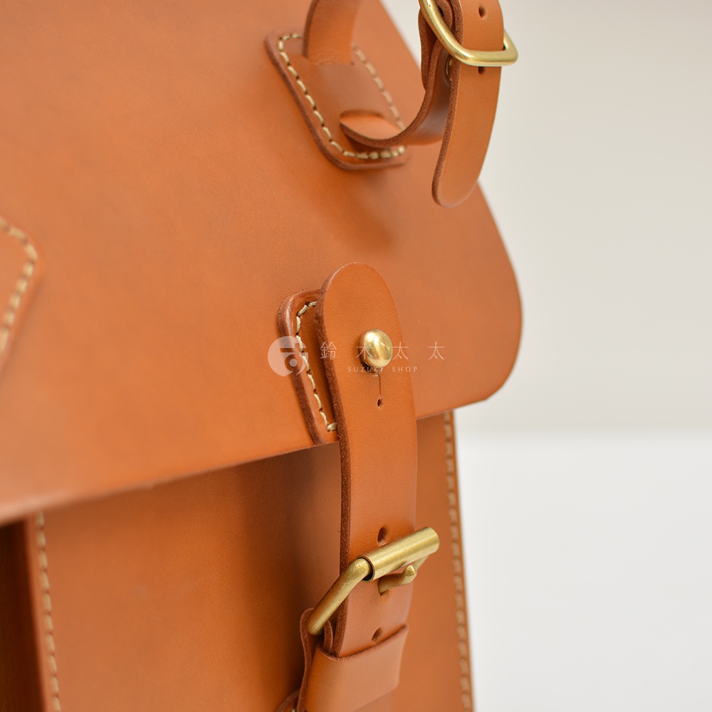 職人手作皮革旅行包 A-102，採用 tan 色全粒面皮革製作，配有黃銅搭扣和縫線細節。
