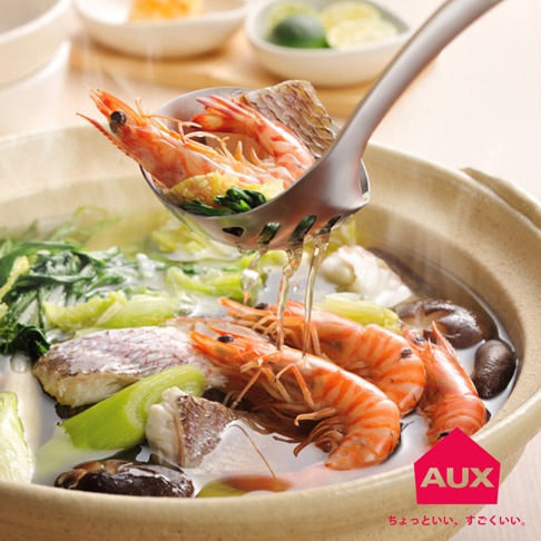 不鏽鋼濾湯火鍋杓，正在撈起鍋中的鮮蝦、魚片、青菜與香菇。