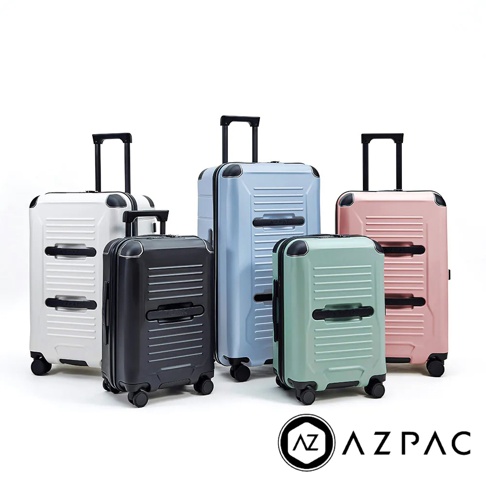 五個不同尺寸的 AZPAC Trucker 2.0 旅行箱，依序為白色、黑色、淺藍色、淺綠色和粉紅色，皆配有可伸縮拉桿和萬向輪。