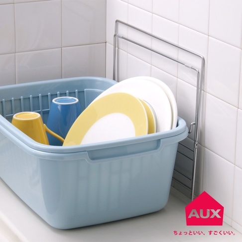 淺藍色塑膠瀝水籃中，擺放著黃色與藍色馬克杯，以及黃色邊緣的白色盤子。右側為銀色金屬折疊式晾曬架。