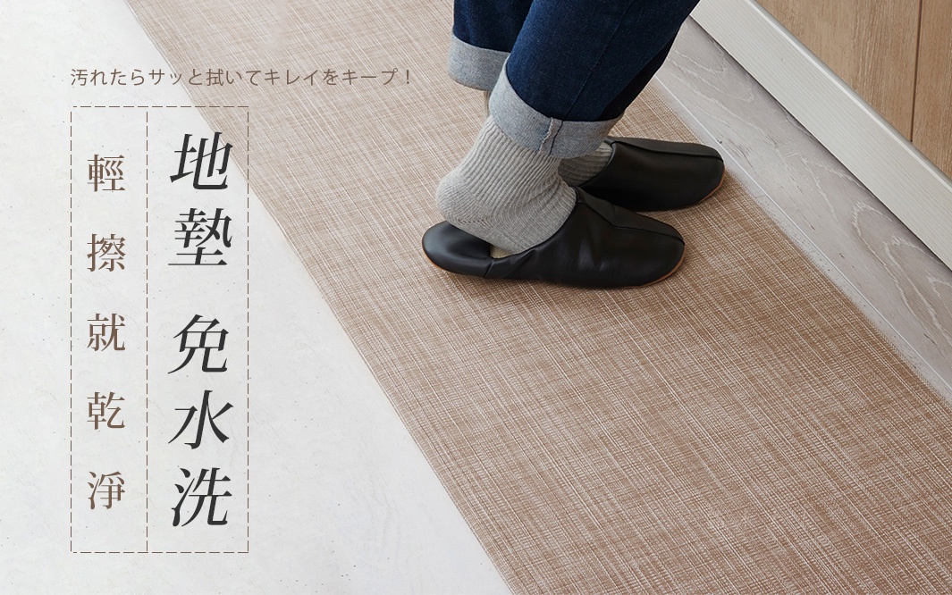 可擦拭的淺褐色廚房地墊，帶有細緻的織紋，展示了穿著黑色拖鞋和灰色襪子的人的腳。