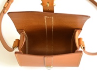 職人手作皮革皮扣單肩包，淺棕色，天然皮革材質，包蓋開啟，露出內部空間，一側有皮質提環和金屬扣環。