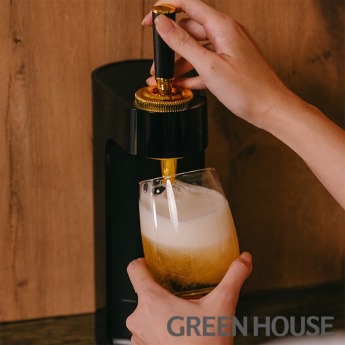 GREEN HOUSE品牌超音波四代金泡機，以黑色機身搭配金色拉桿，正在為玻璃杯注入啤酒，產生豐富綿密的金黃色泡沫。