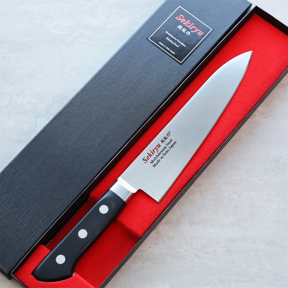 鉬釩不鏽鋼牛刀，刀刃長18公分，帶有黑色手柄，裝於紅色內襯的黑色禮盒中。