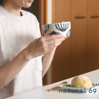 手繪附耳湯杯，白色杯身上有黑色線條繪製的植物圖案，杯身兩側有小耳朵，溫潤的陶瓷材質，適合盛裝湯品或飲品。