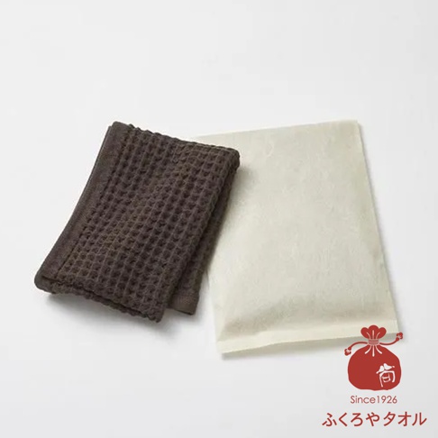 深棕色格子紋理毛巾與米白色紙張並排擺放，右下角有紅色印章圖案與日文文字Since1926ふくろやタオル