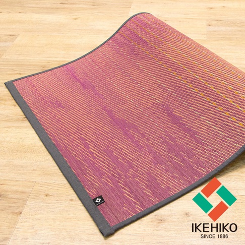 藺草編織瑜珈墊，主體為粉紫與淺棕交織的紋理，邊緣為灰色包邊，材質為藺草。