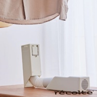 recolte 烘被機，有著奶油白色機身，配件軟管連接到主機，背景為淺色窗簾。