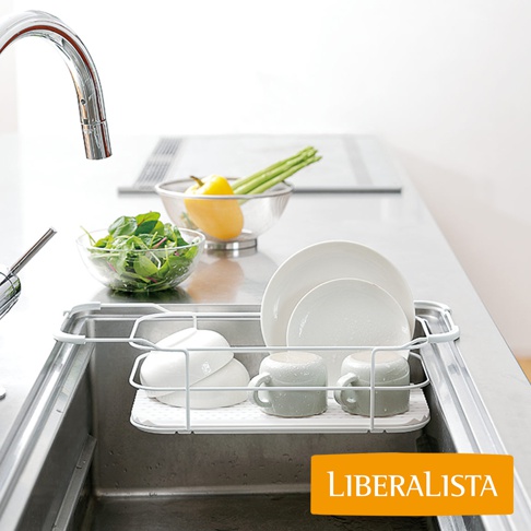 LIBERALISTA 水槽多功能瀝水籃架，包含碗盤、杯子，上方另有蔬菜和水果，旁邊是水龍頭。