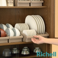 一個人的手正在從右側取出一個淺褐色的盤子架，架子裡有數個白色圓盤。