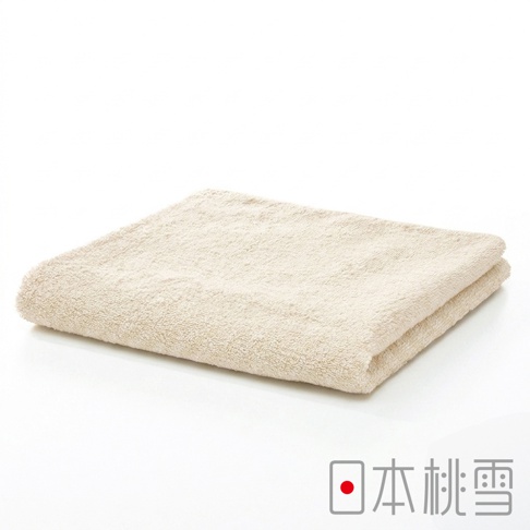 一張疊好的米色長方形精梳棉毛巾，表面呈現柔軟的毛圈質感，置於簡潔的白色背景中央，右下角印有紅點與日本桃雪的品牌名稱字樣。