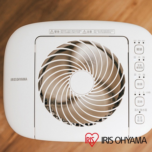 白色IRIS OHYAMA乾燥循環除濕機，頂部中央為白色螺旋狀扇網，右側為功能按鍵面板，標示有擺頭、空氣循環、除濕、定時、滿水/無水箱、電源開/關等選項。