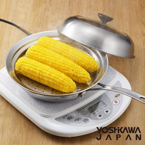 不鏽鋼蒸鍋盤內放有三個黃色玉米，蒸鍋盤上有蒸汽冒出，蓋子為不鏽鋼材質，邊緣有透明玻璃。