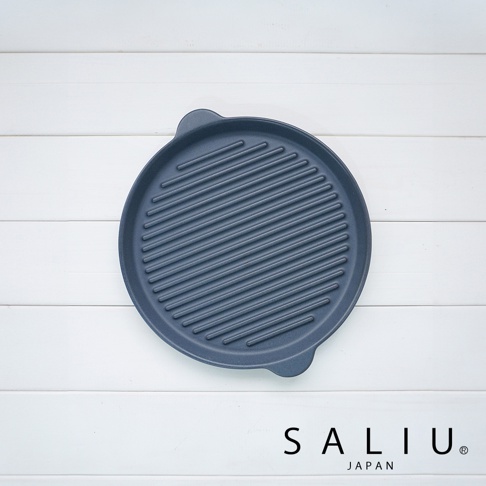 深藍色圓形陶製烤盤，表面有明顯的平行烤紋，兩側有握把。