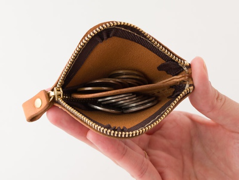 職人手作皮革分隔收納零錢包，淺棕色皮革，內有分隔層，裝有硬幣，搭配金色拉鍊。