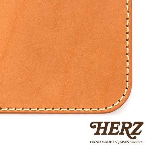 HERZ 品牌標誌，下方為 HAND MADE IN JAPAN Since1973，並展示了皮革製品的細節，包括縫線與材質的特寫。