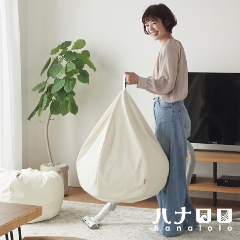 米白色皮革材質的懶骨頭沙發，呈水滴狀，頂部有提把，一旁另有同款米白色方形懶骨頭沙發。