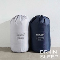 太空科技調溫被-雙人被，左為淺灰色，右為深藍色，兩款皆為抽繩束口收納袋裝，印有「BRAIN SLEEP SHIELD COMFORTER」字樣及相關技術說明。