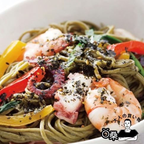 綠色蕎麥麵上鋪滿了鮮蝦、章魚塊、紅黃彩椒和海苔芝麻香鬆，色彩豐富，擺盤誘人。