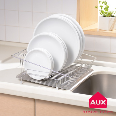 不鏽鋼方形瀝水籃，置放著四個不同尺寸的白色圓盤，瀝水籃底部有長條狀的排水孔設計，整體呈現簡潔實用的風格。