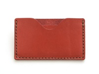 職人手作皮革卡片夾，採用紅色皮革製成，邊緣縫線為深棕色，設計簡潔，可容納多張卡片。