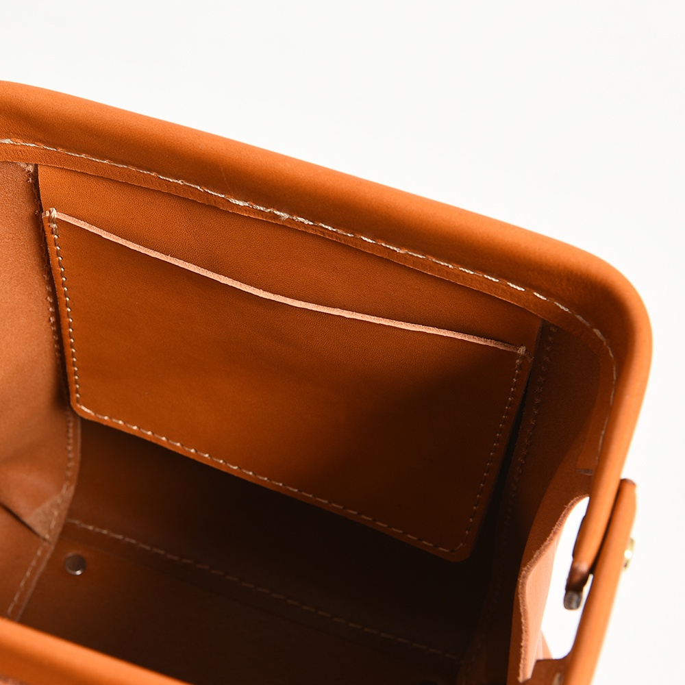 職人手作皮革迷你後背醫生包，特寫包內結構，展示棕褐色皮革內袋與縫線細節。