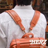 職人手作皮革Big肩墊，淺棕色，搭配白色襯衫，展示皮革材質的紋理和縫線細節。