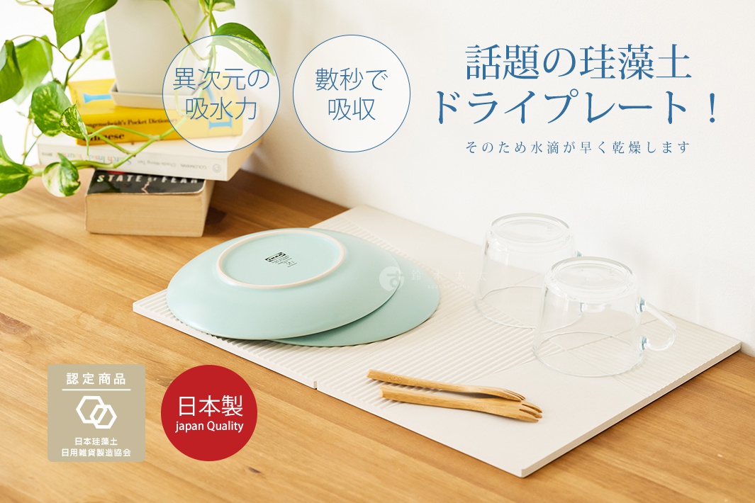 淺綠色珪藻土置物墊，上面放著兩個疊放的盤子、兩個玻璃杯和一雙竹筷。置物墊為米白色，表面有斜面拼接紋路。