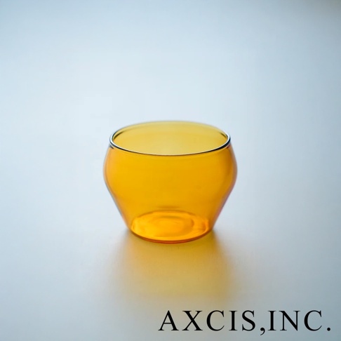 琥珀色透明玻璃杯，圓潤復古造型，底部略寬，杯口有細黑邊。