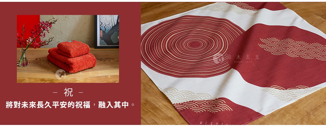 一件日本製和緣紋樣風呂敷毛巾，帶有富士山和波浪圖案，搭配兩塊柔軟的紅色毛巾和一瓶紅色小花，背景為木質桌面。