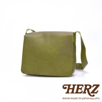 日本 HERZ 品牌綠色皮革軟皮斜背包，包身上有壓印的 Z 字樣，下方有 HERZ 品牌標誌與 HAND MADE IN JAPAN Since1973 字樣