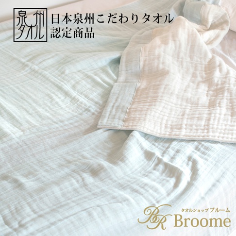 淺藍色與米白色四層紗毛巾毯，材質輕盈，呈現自然的褶皺紋理，適合蓋在身上。