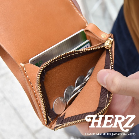 職人手作皮革小型雙折短夾，淺棕色，打開的零錢夾內有硬幣，內層可見兩張信用卡。