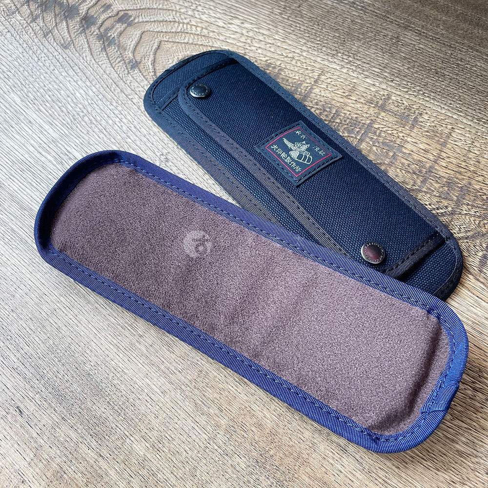 兩件深藍色純棉帆布製成的肩墊，其中一件內裡為絨布材質，外層印有品牌標誌。