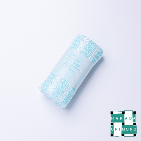 藍白兩色相間、網狀紋理的泡泡洗澡巾，捲起後用透明標籤紙包裹，標籤上印有日文產品資訊。