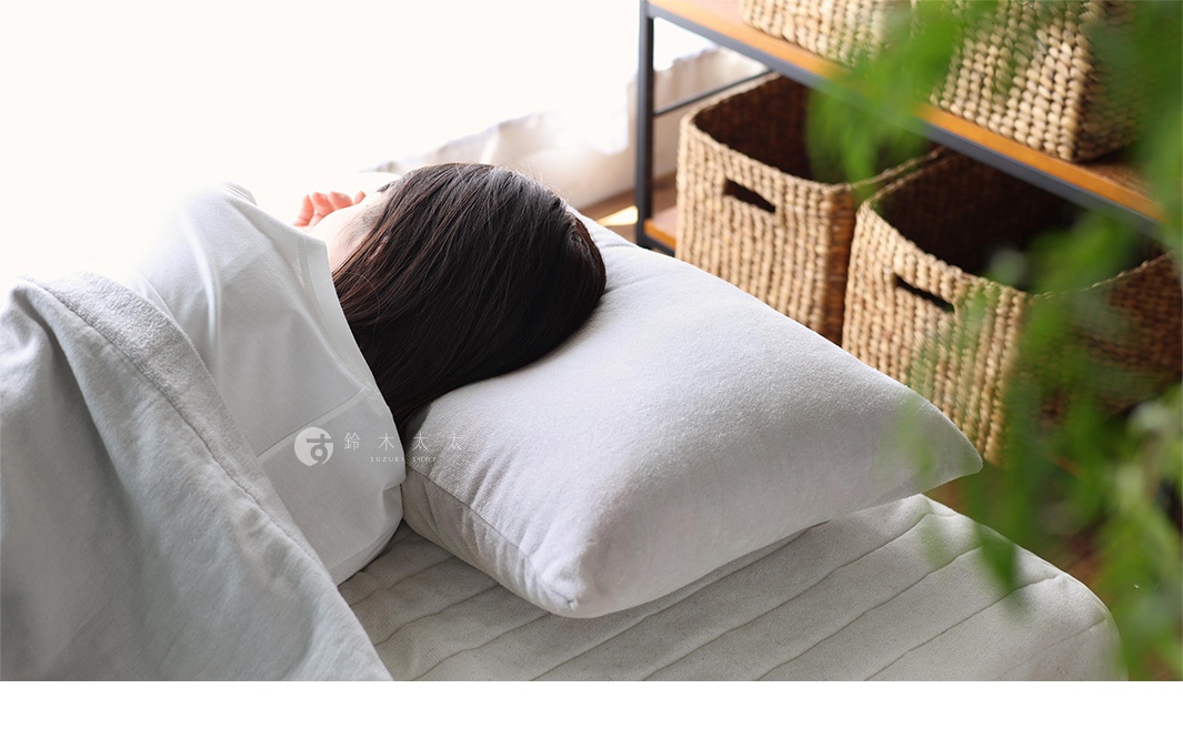 白色吸濕透氣絲絨風毛巾枕套，觸感柔軟，搭配淺灰色床單，背景為草編收納籃。