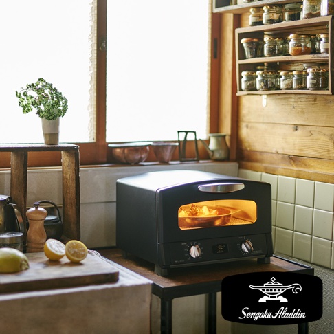 黑色復古多用途烤箱，內部有食物正在烘烤，配有銀色把手和兩個旋鈕。