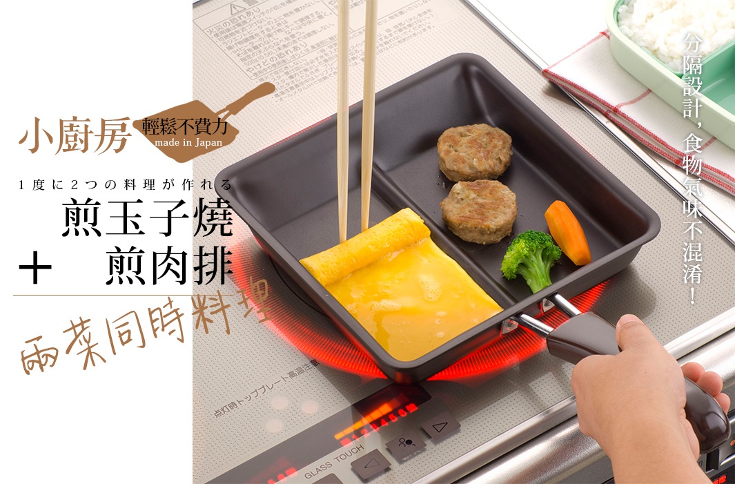 一個深灰色的二合一分格平底鍋，鍋中包含煎蛋捲、兩塊煎肉餅、一小塊花椰菜和一根胡蘿蔔。鍋柄為咖啡色，鍋底有紅色加熱指示。
