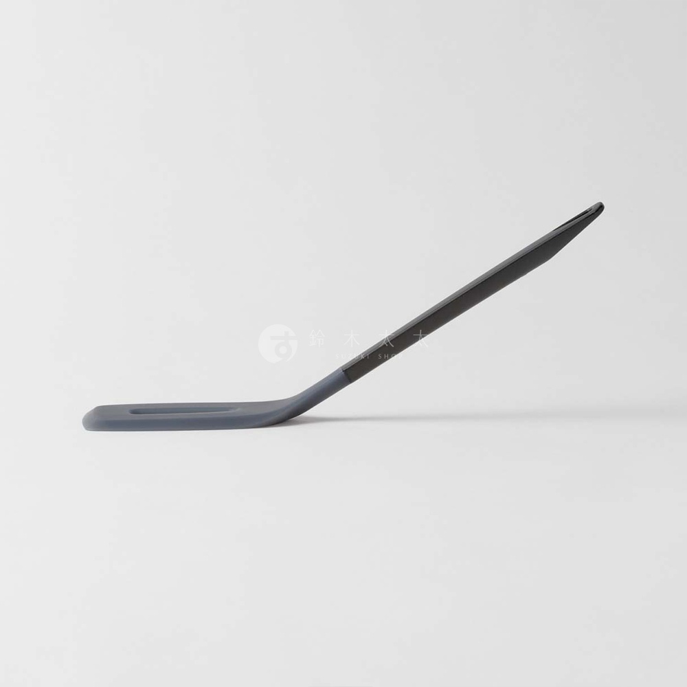 MARNA TRYANGIRP 三角耐熱矽膠料理煎鏟，灰色矽膠鏟頭與深灰色手柄，以優雅的曲線斜立於白色背景上。