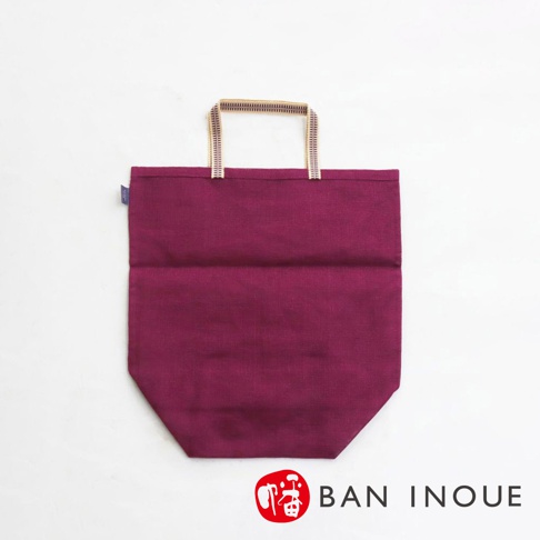 深紫色提把式收納袋，由布料製成，有兩條對比色的提把。