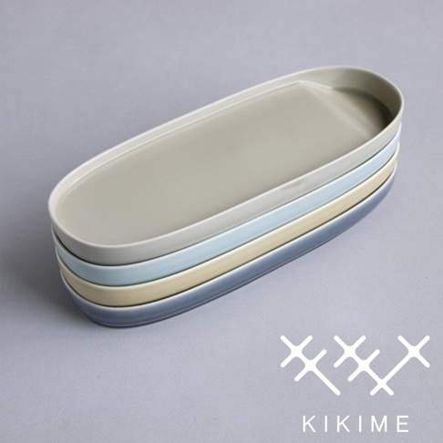 疊放的波佐見燒長型主菜盤，顏色由上至下分別為淺灰、淺藍、淺黃、淺灰藍。盤子為橢圓形，邊緣微翹，表面光滑。