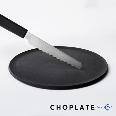 黑色圓形砧板盤上放著一把銀色不鏽鋼鋸齒刀，刀柄為黑色。