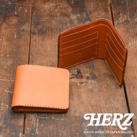 職人手作皮夾，兩個皮夾皆為二折橫式設計，其中一個皮夾為閉合狀態，呈現淺棕色皮革，邊緣縫線明顯；另一皮夾為展開狀態，內有多個卡槽，顏色較深，呈現焦糖棕色，內裡有品牌標誌。