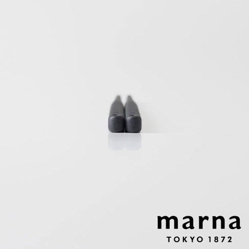 marna TOKYO 1872 品牌下，一雙黑色矽膠材質的長筷，以極簡的白色背景進行拍攝，筷子的細長部分向上微微傾斜，底部呈現方形，並帶有反光效果。