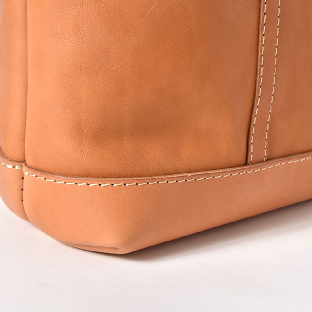 棕褐色皮革托特包底部特寫，帶有縫線細節。