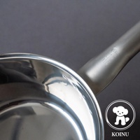 三層不鏽鋼雪平鍋，鍋身呈現金屬光澤，帶有長柄，鍋柄上刻有「KOINU MADE IN JAPAN」字樣及品牌標誌。