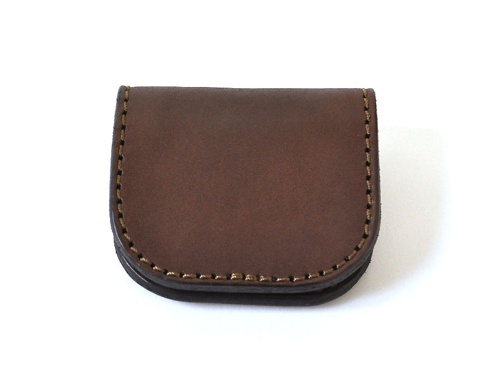 深棕色皮革製作的馬蹄形零錢包，邊緣以對比色縫線手工縫製，呈現簡潔的U形開口設計，材質為天然皮革。