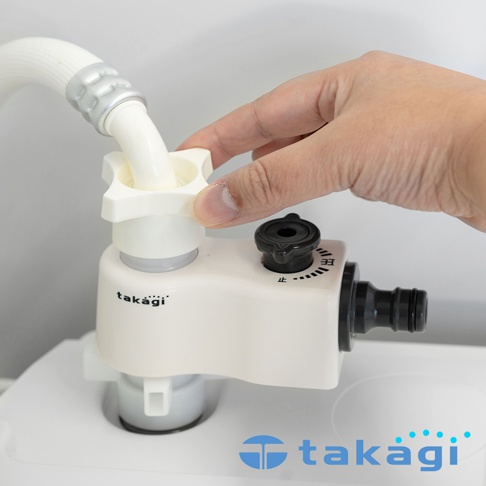 一隻手正在調整安裝於洗衣機水龍頭上的白色Takagi品牌分水轉接頭，轉接頭上方連接白色水管，側邊設有黑色調節旋鈕，標示著止字及流量刻度。