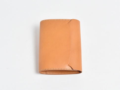 淺棕色皮革製成的 A6 記事本書套，呈現簡潔的設計，邊緣有縫線裝飾。