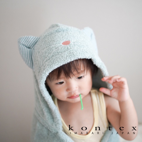 淺藍色今治純棉連帽浴巾，帶有可愛的貓耳造型，嬰兒穿著，浴巾材質柔軟，帶有細緻條紋。